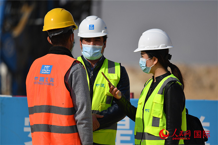 2012年12月27日，人民网记者（右一）在中建阿拉曼项目工地采访埃方员工。人民网记者 李凉摄